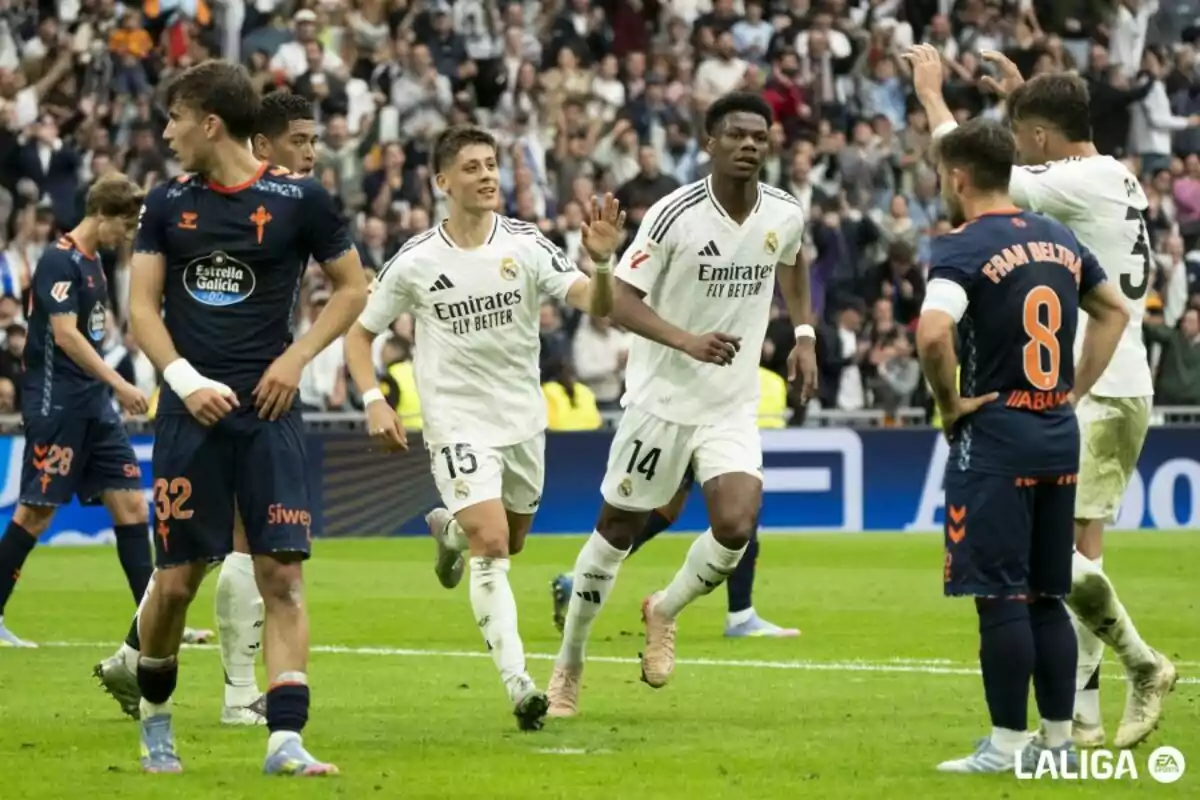 Soccer players on the field during a match, with some wearing white uniforms and others dark ones, while the audience watches from the stands. Soccer players on the field during a match, with some wearing white uniforms and others dark ones, while the audience watches from the stands.