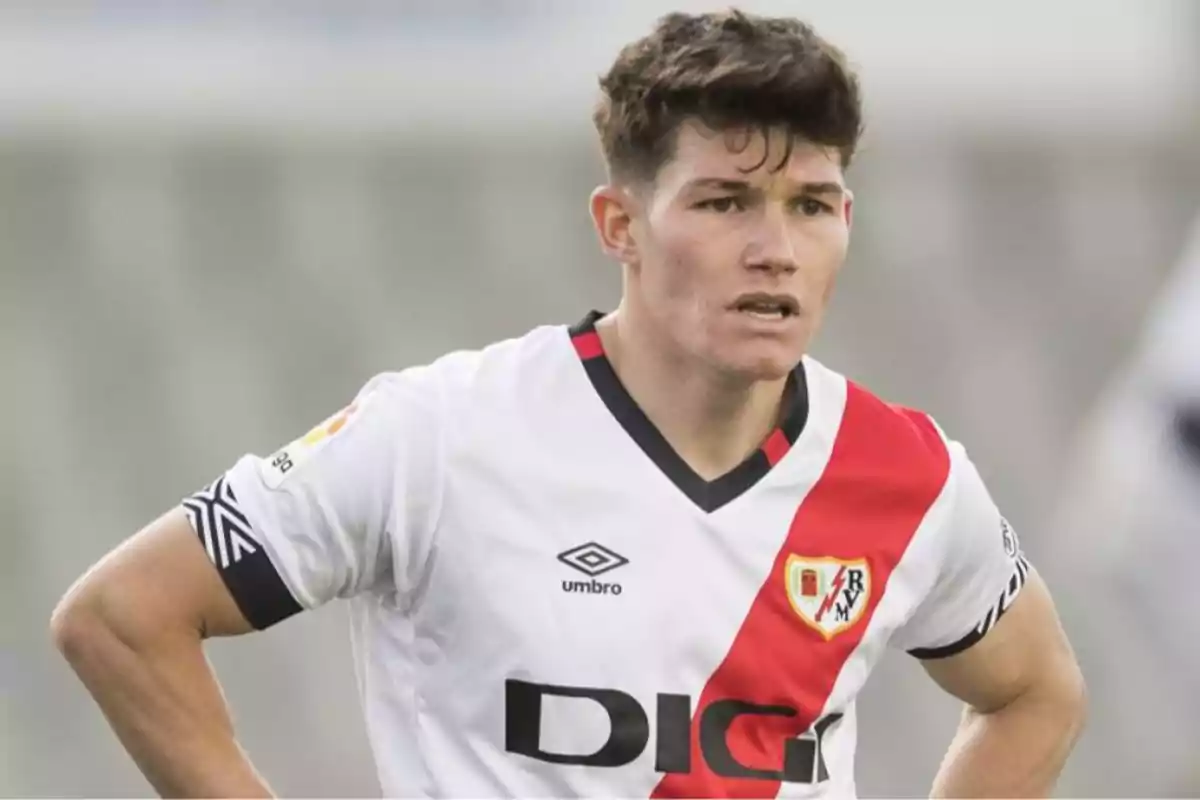 Un jugador de fútbol con el uniforme del Rayo Vallecano en el campo.