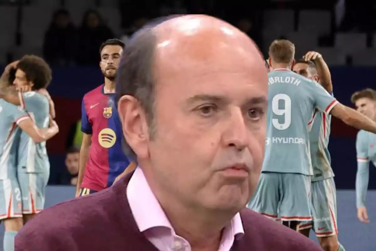 Un hombre en primer plano con un grupo de jugadores de fútbol celebrando en el fondo.