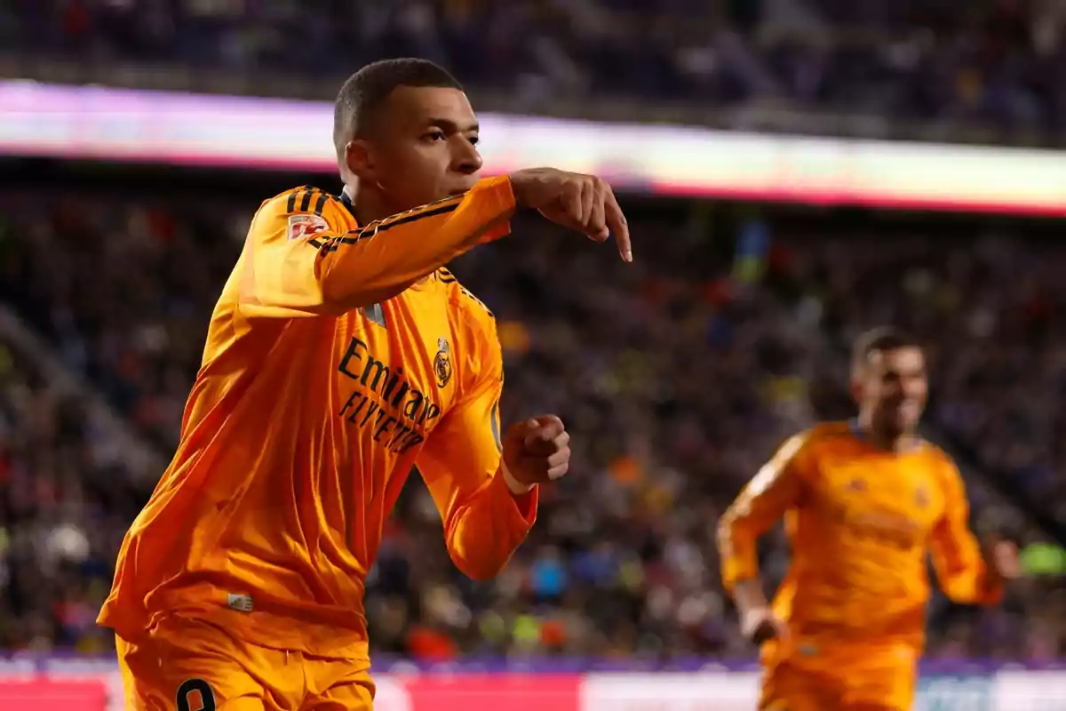 A player in an orange uniform celebrates on the field during a match.