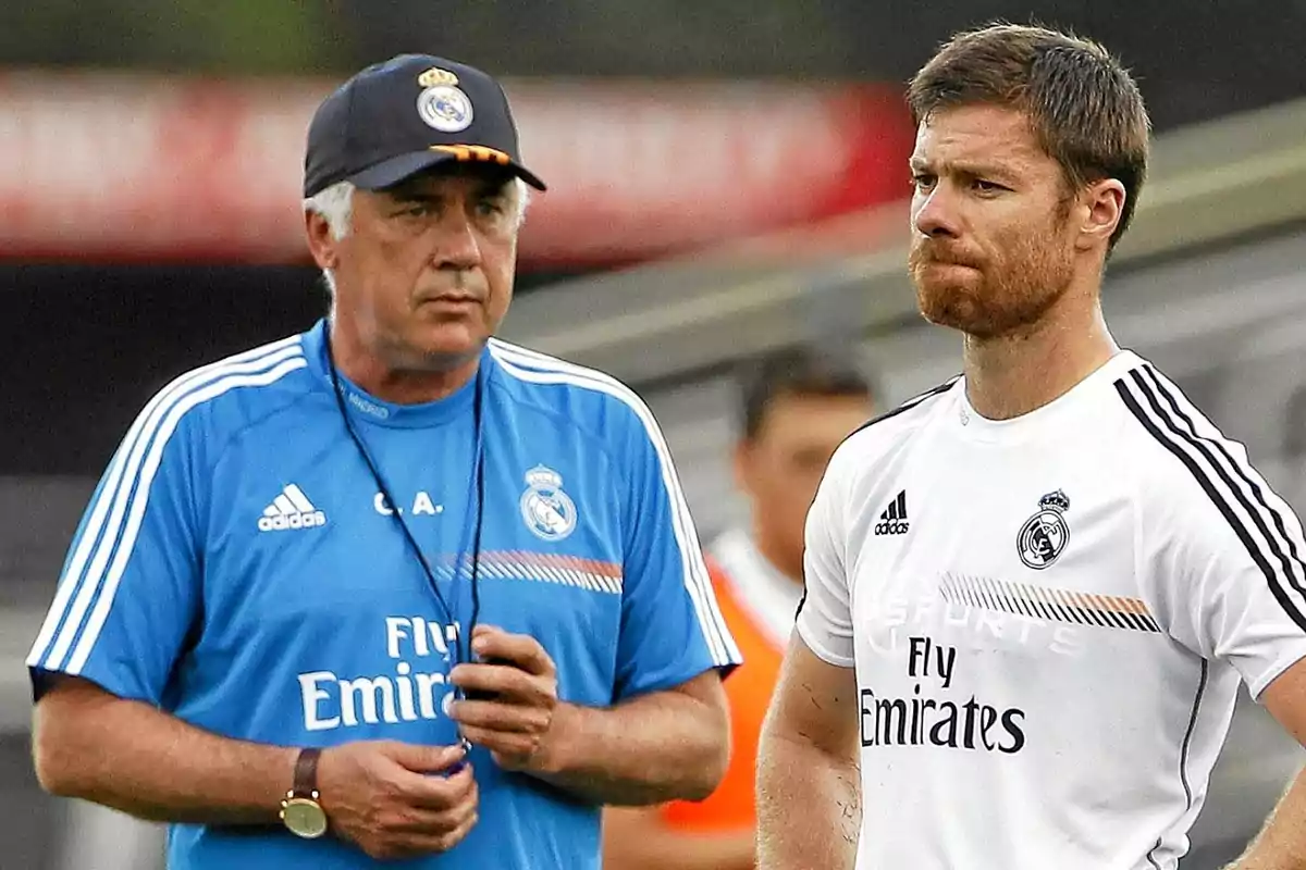 Two people wearing Real Madrid training gear are closely observing something outside the frame.