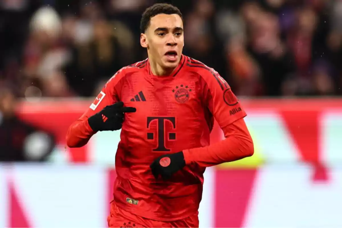 Jugador de fútbol con uniforme rojo del Bayern Múnich en el campo de juego.