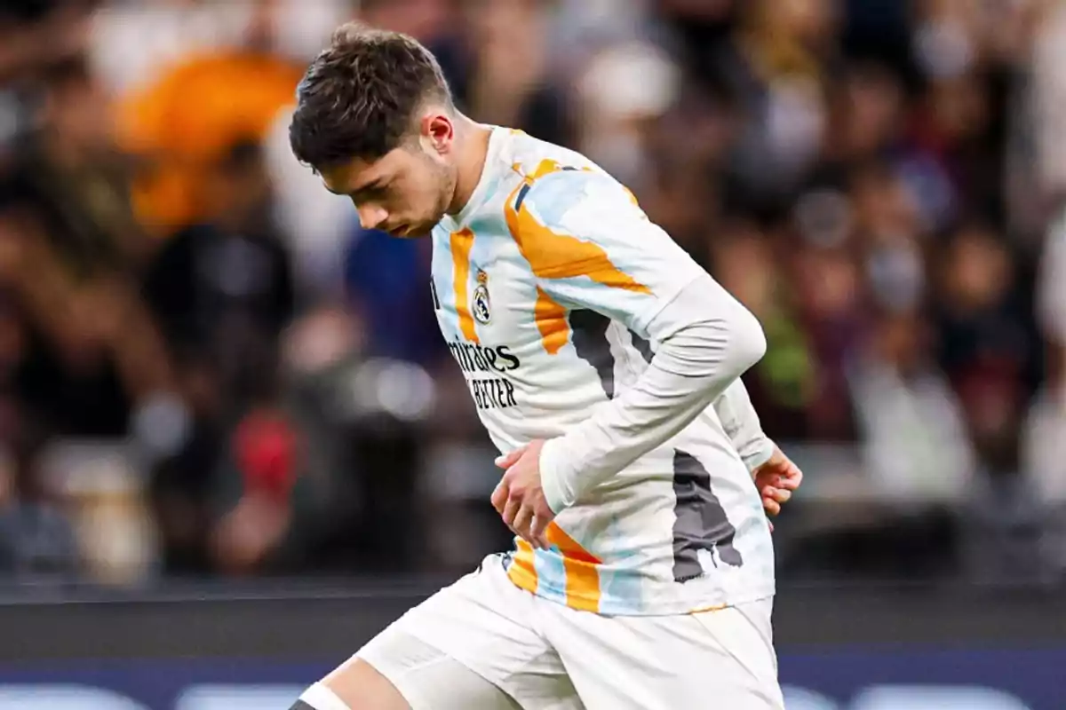 Soccer player in white uniform with orange details on the field. Soccer player in white uniform with orange details on the field.