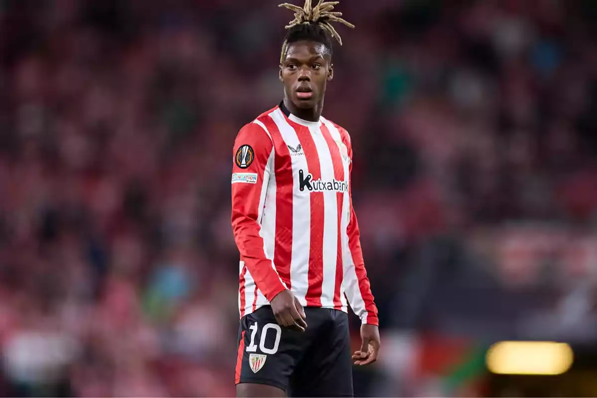 Un jugador de fútbol con uniforme rojo y blanco en el campo.