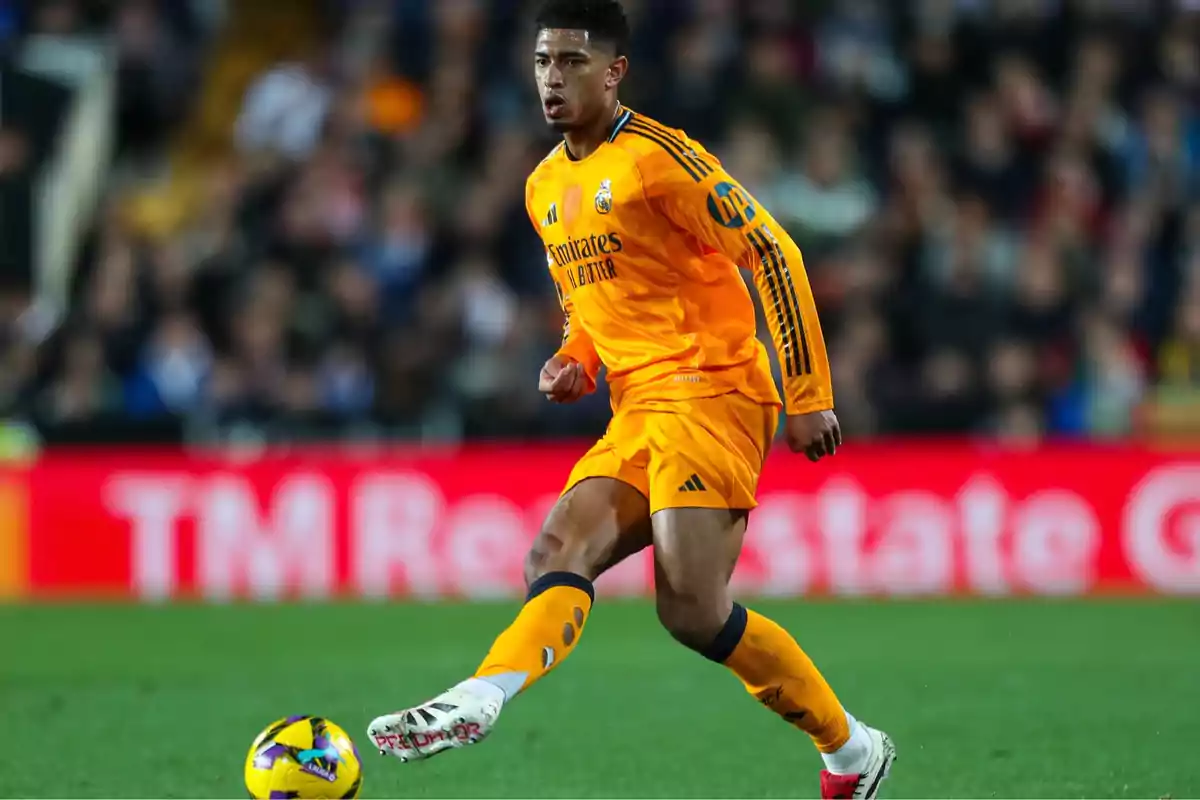 A soccer player in an orange uniform controls the ball on the field during a match. A soccer player in an orange uniform controls the ball on the field during a match.