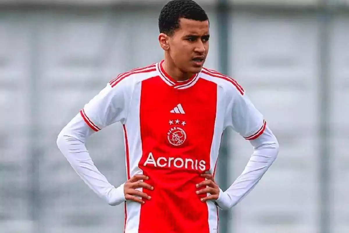 Young player in an Ajax Amsterdam uniform standing on the field with hands on hips Young player in an Ajax Amsterdam uniform standing on the field with hands on hips