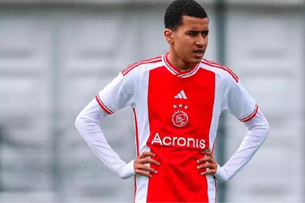 Young player in an Ajax Amsterdam uniform standing on the field with hands on hips Young player in an Ajax Amsterdam uniform standing on the field with hands on hips