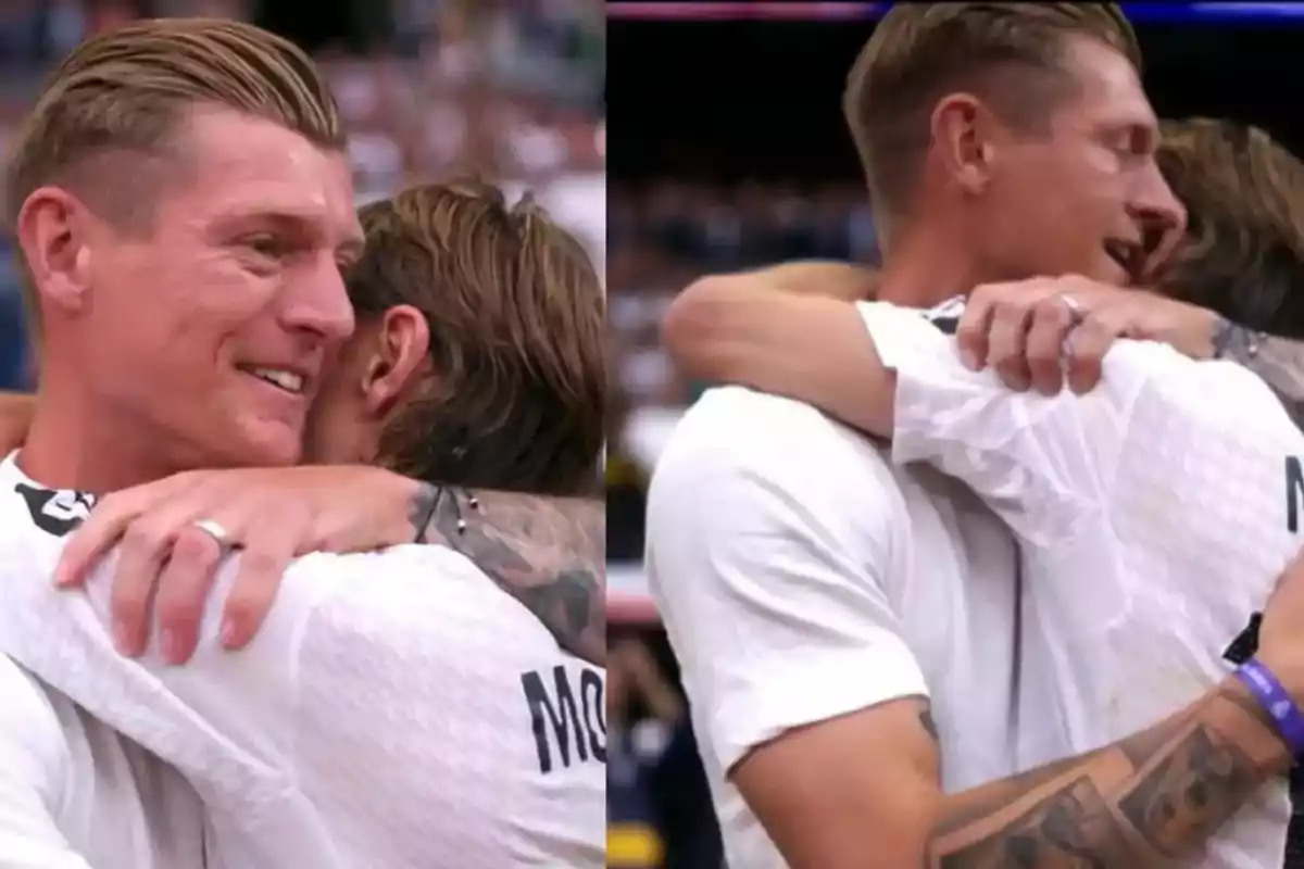 Dos personas se abrazan con emoción en un evento deportivo, ambas visten camisetas blancas y una de ellas tiene un tatuaje visible en el brazo. Dos personas se abrazan con emoción en un evento deportivo, ambas visten camisetas blancas y una de ellas tiene un tatuaje visible en el brazo.