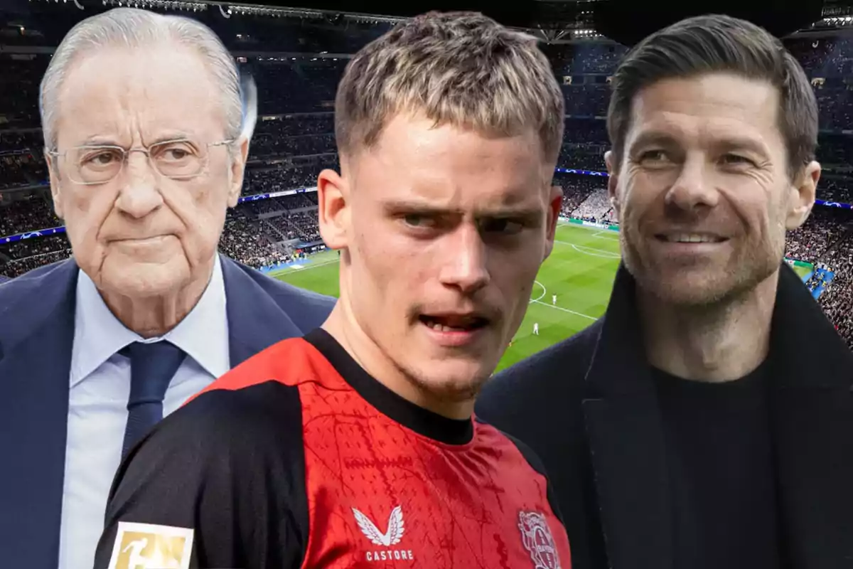 Three men in a soccer stadium, one of them wearing a red jersey of a sports team.