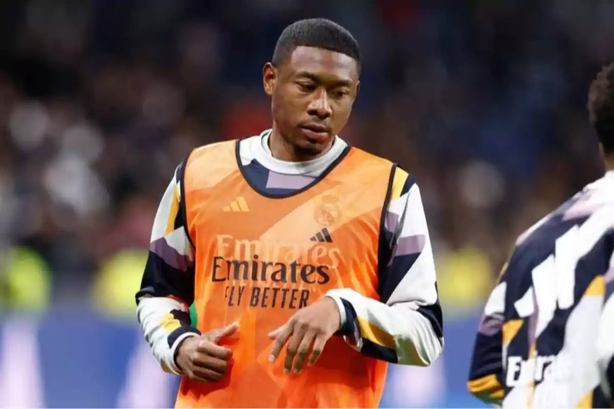 Real Madrid player wearing an orange training bib during warm-ups at a stadium Real Madrid player wearing an orange training bib during warm-ups at a stadium