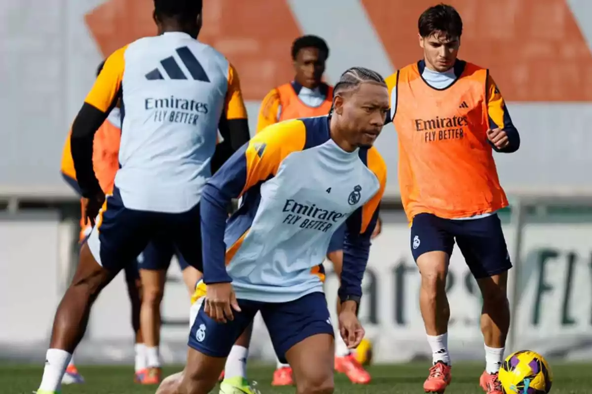 Jugadores de fútbol del Real Madrid entrenando en el campo con uniformes de entrenamiento.