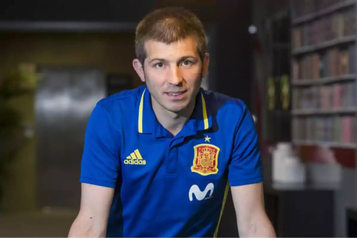 Man wearing a blue Spanish futsal national team jersey in an indoor setting Man wearing a blue Spanish futsal national team jersey in an indoor setting