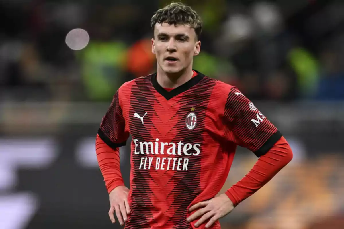 Football player in red and black AC Milan uniform on the playing field. Football player in red and black AC Milan uniform on the playing field.