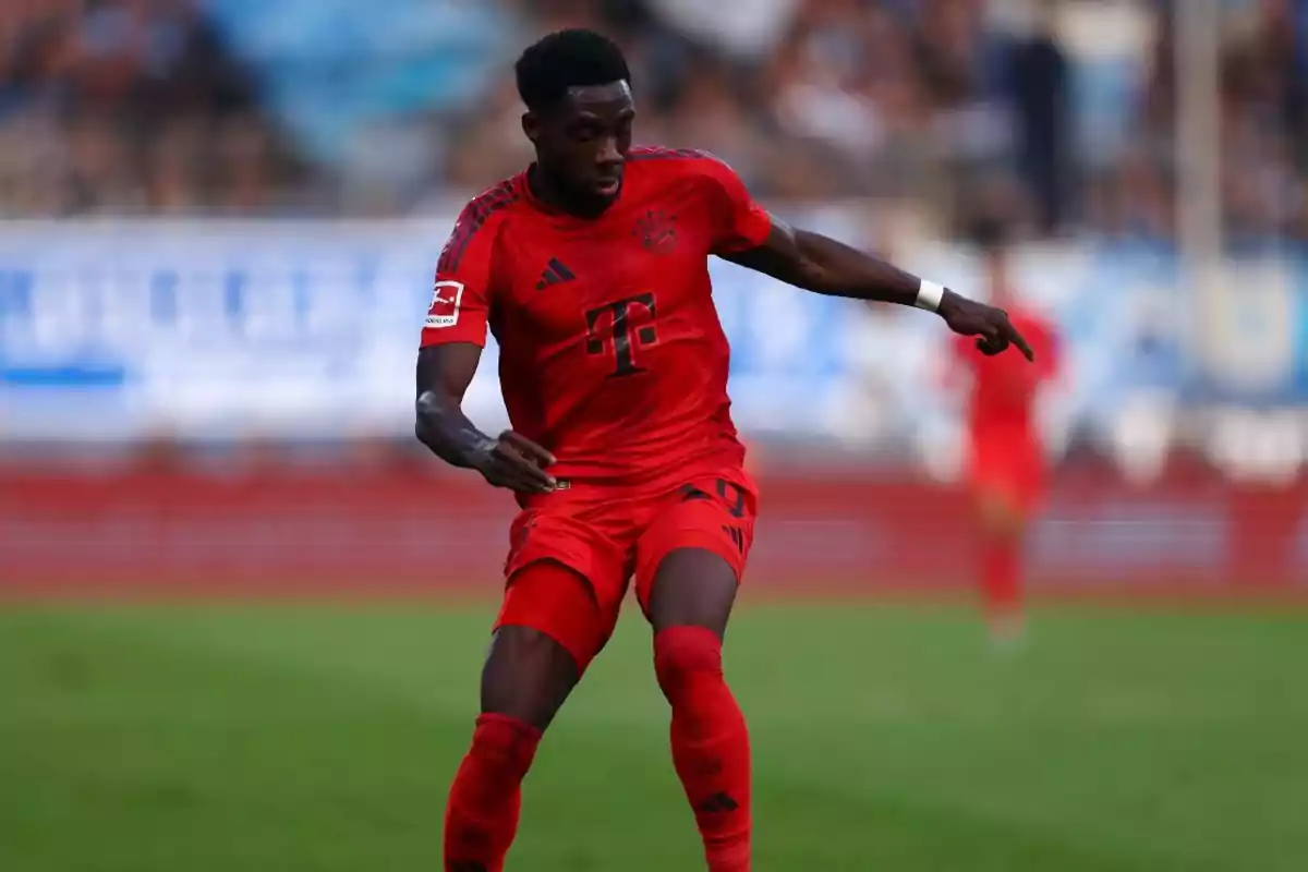 Jugador de fútbol con uniforme rojo en acción durante un partido.