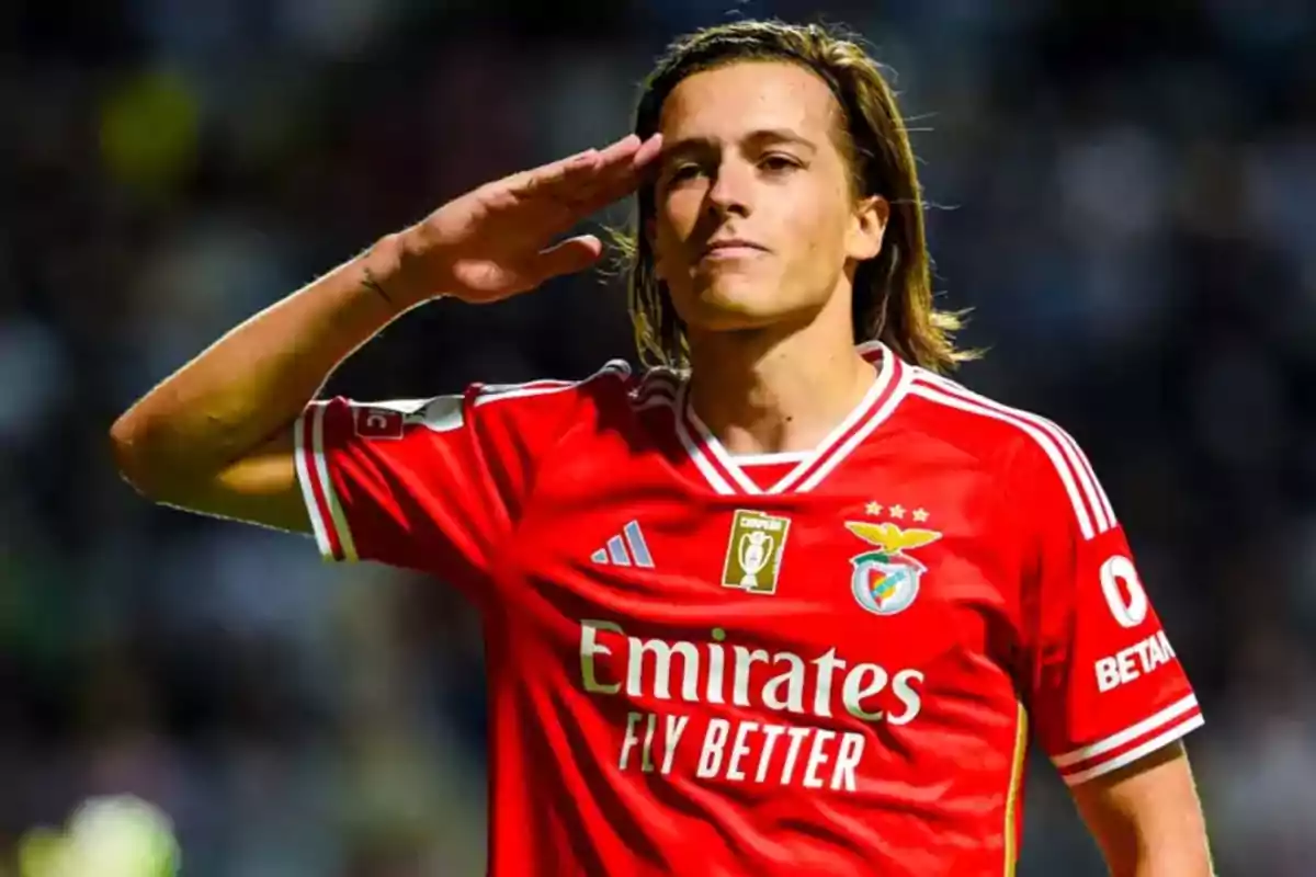 Soccer player in a red Benfica uniform giving a military salute during a match Soccer player in a red Benfica uniform giving a military salute during a match