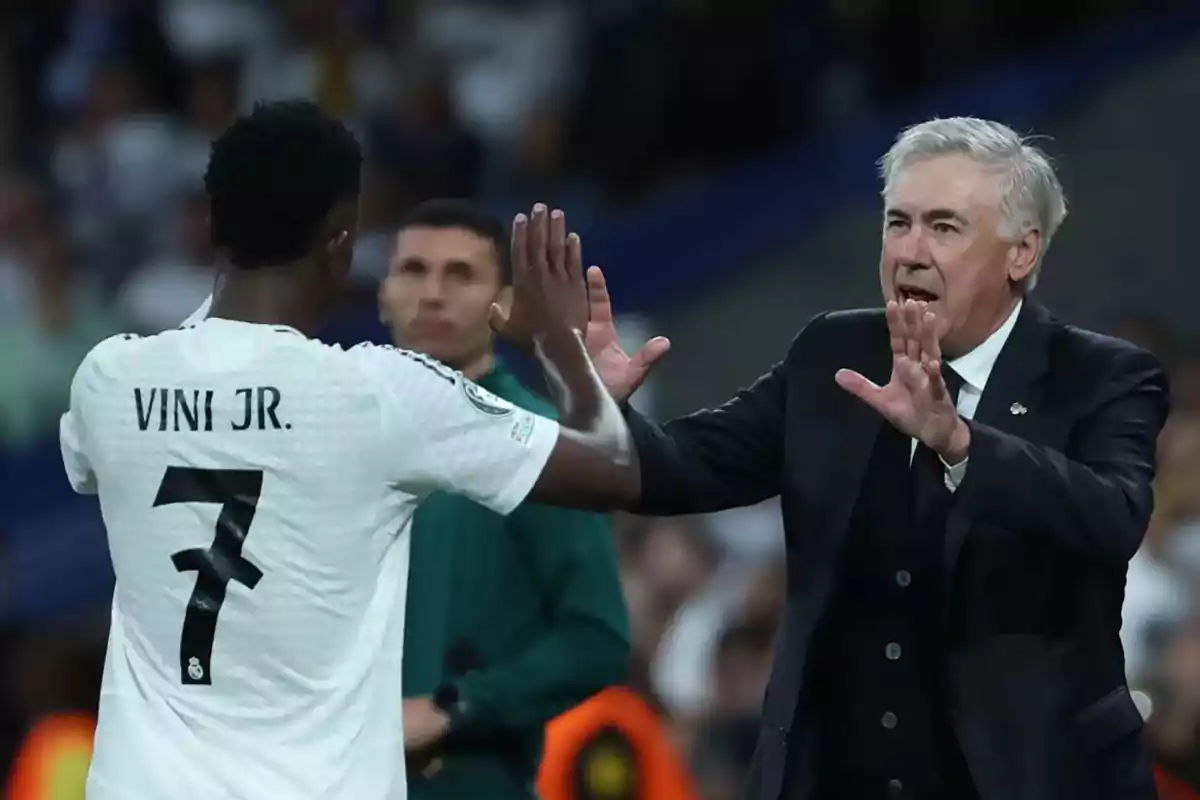 A player and a coach greet each other on the field during a match. A player and a coach greet each other on the field during a match.