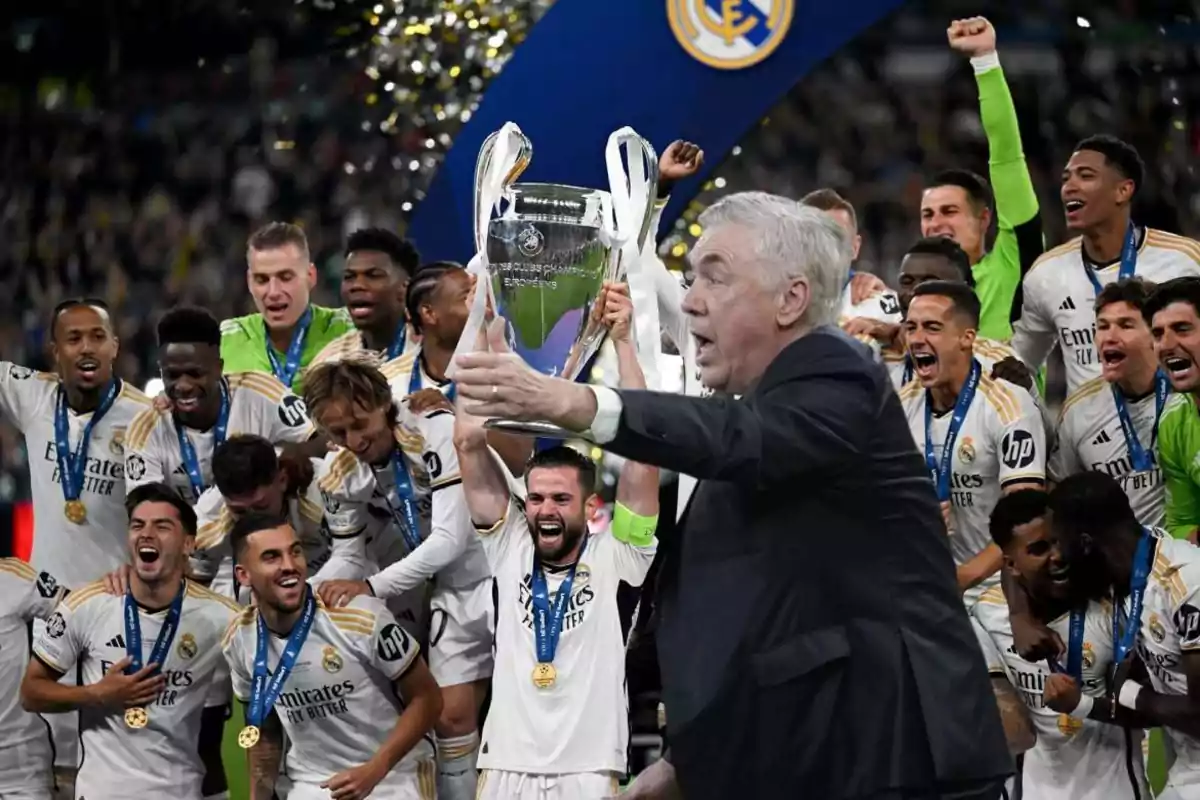 A soccer team celebrates enthusiastically as a man holds a large, shiny trophy.