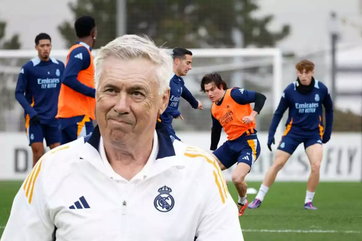 A soccer coach watches his players training on the field.