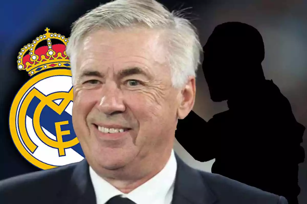 A smiling man with grey hair and a dark suit in front of the Real Madrid crest.