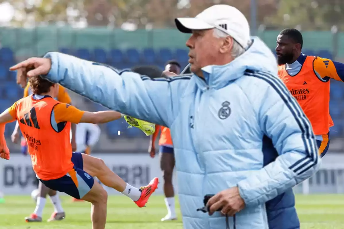 Football coach giving instructions to players during a practice on the field.