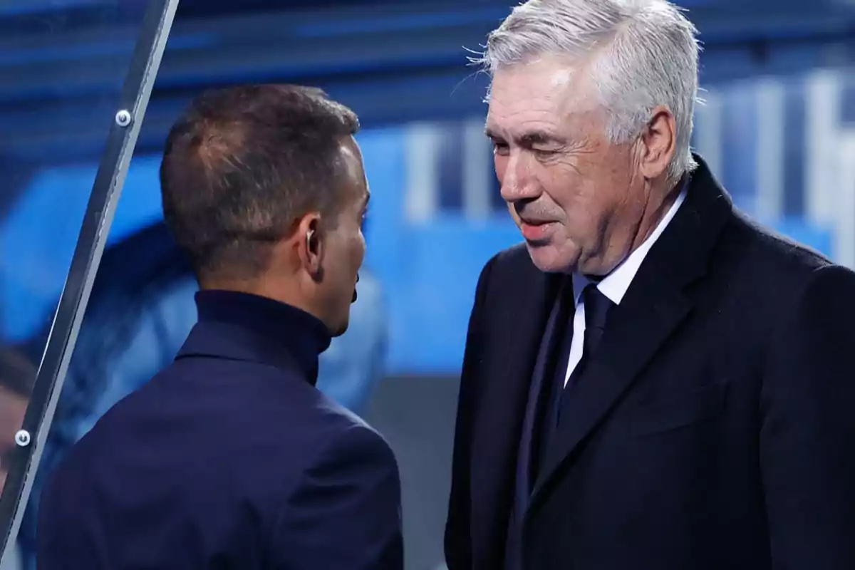 Two men talking in a sports setting.