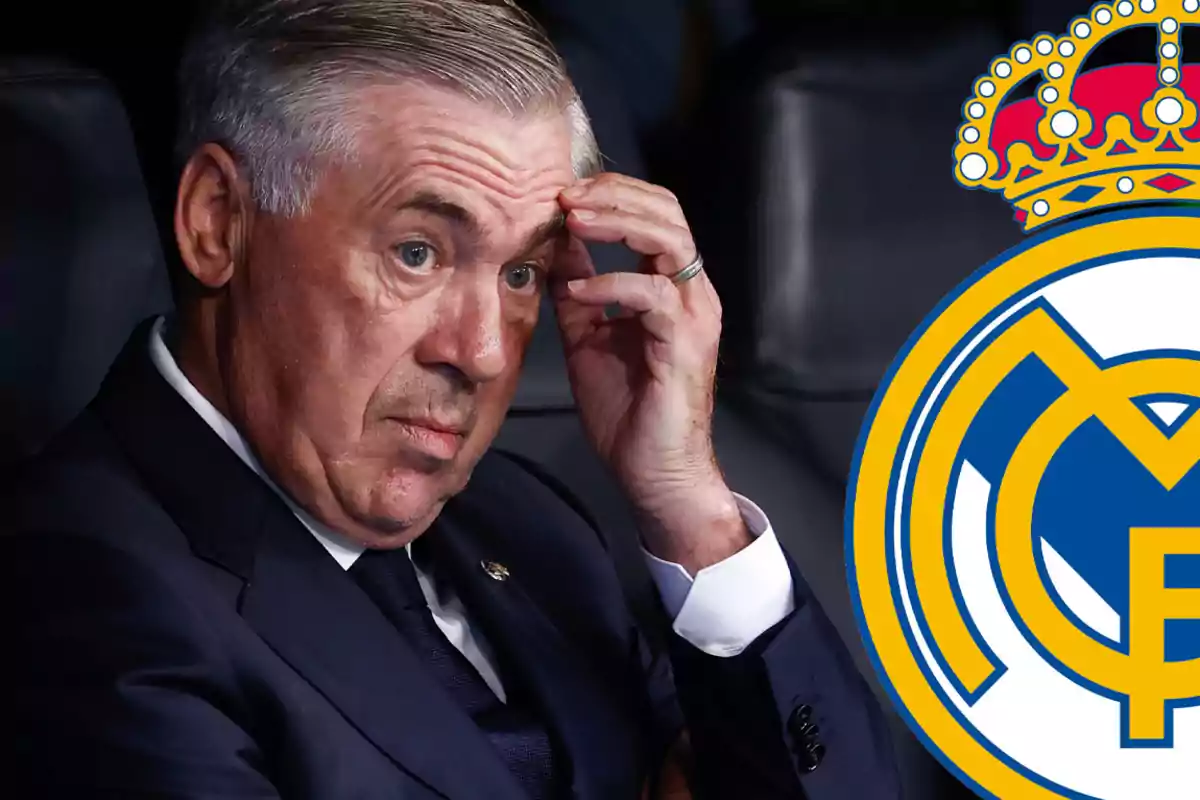 Un hombre en traje oscuro se toca la frente junto al escudo del Real Madrid.