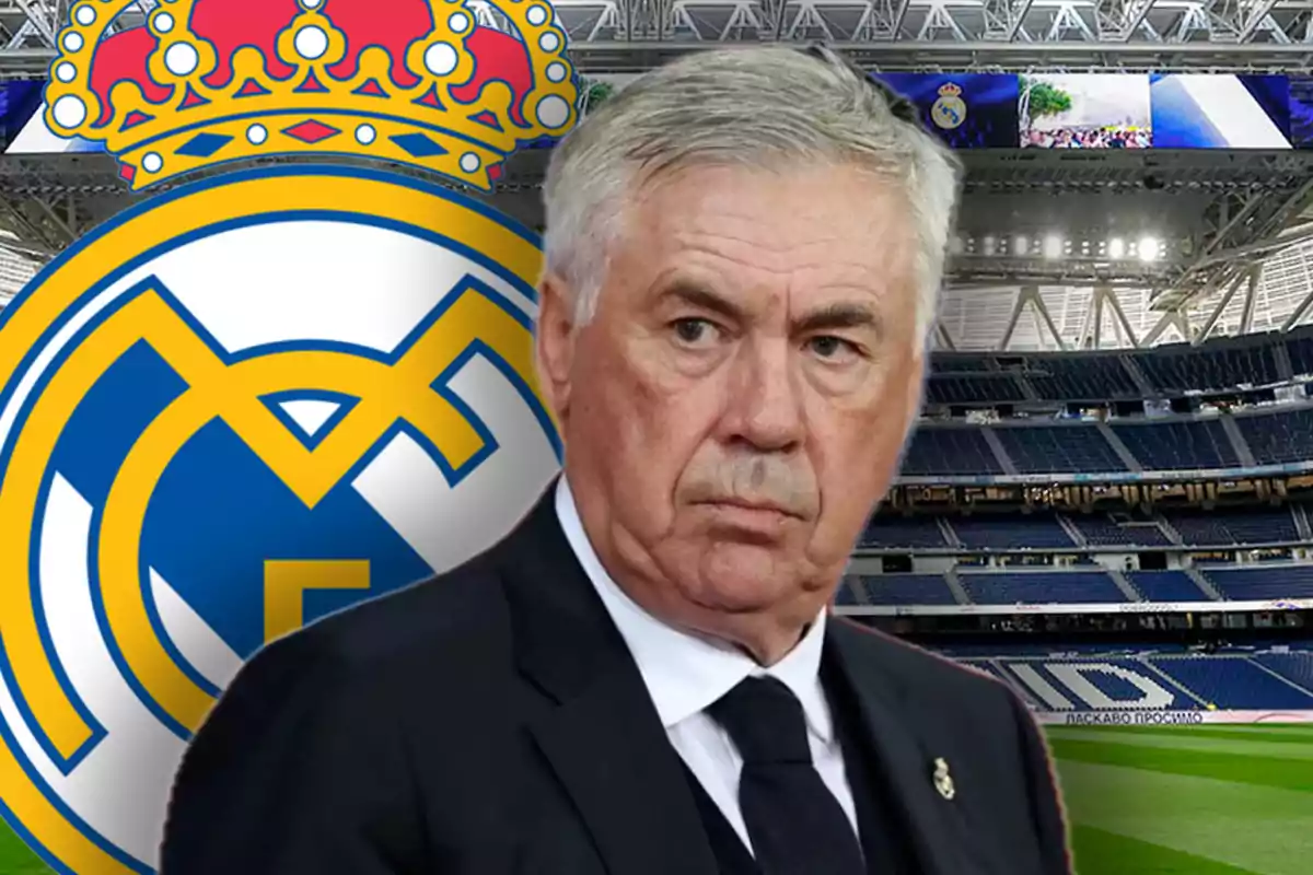 A man in a suit in front of the Real Madrid crest in a soccer stadium.