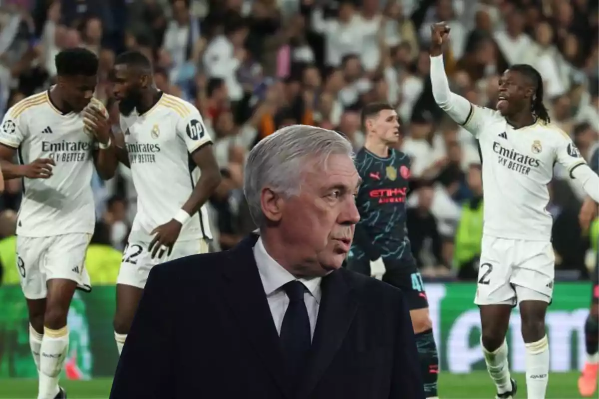 A soccer coach watches as several players celebrate on the field during a match.