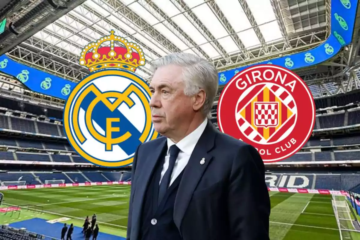 A man in a suit at a soccer stadium with the crests of Real Madrid and Girona FC in the background.