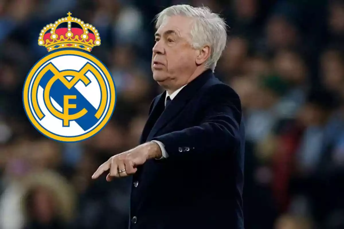 A gray-haired man in a dark suit is pointing with his finger, with the Real Madrid crest beside him.