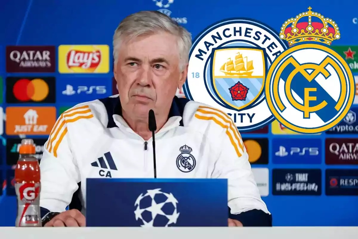 A soccer coach at a press conference with the logos of Manchester City and Real Madrid in the background.