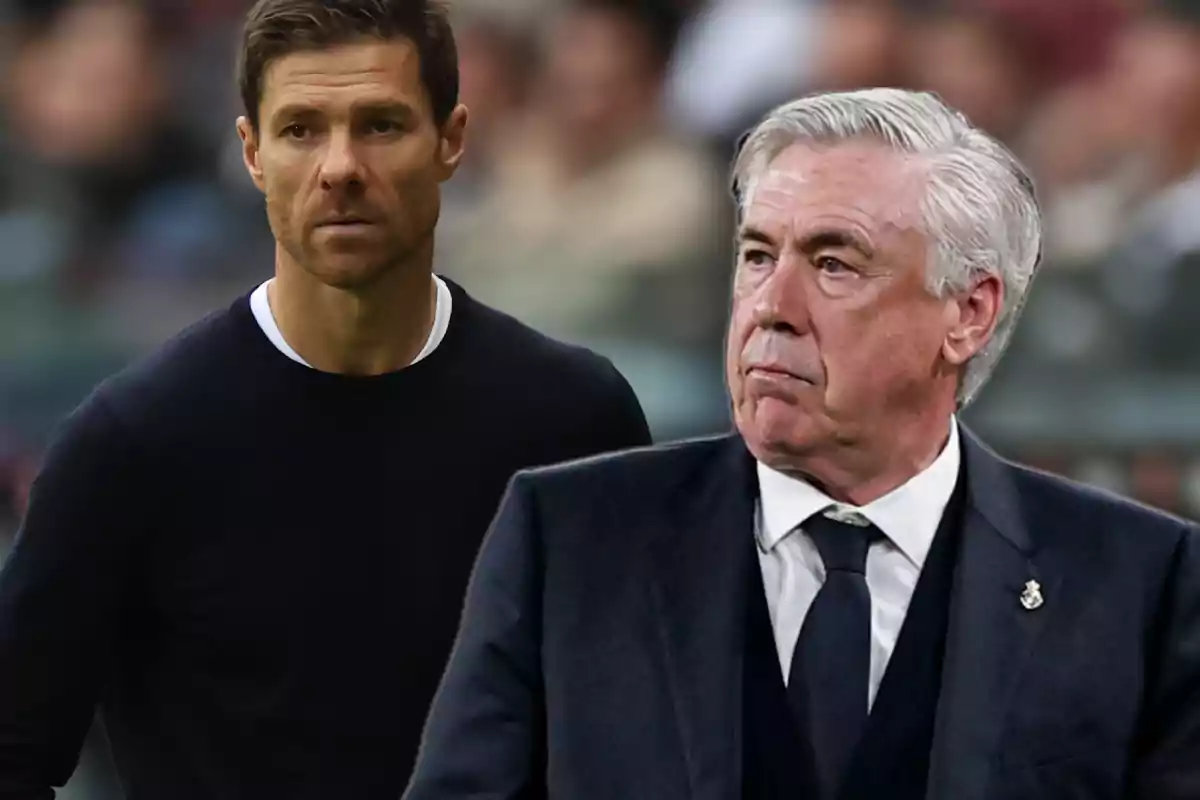 Dos entrenadores de fútbol observan atentamente el campo durante un partido
