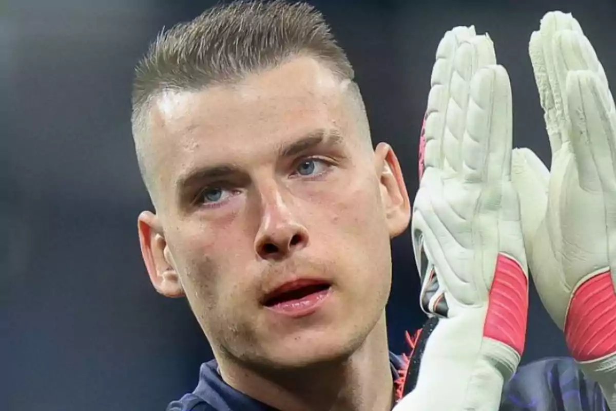 Portero de fútbol con guantes blancos y detalles rojos aplaudiendo durante un partido Portero de fútbol con guantes blancos y detalles rojos aplaudiendo durante un partido