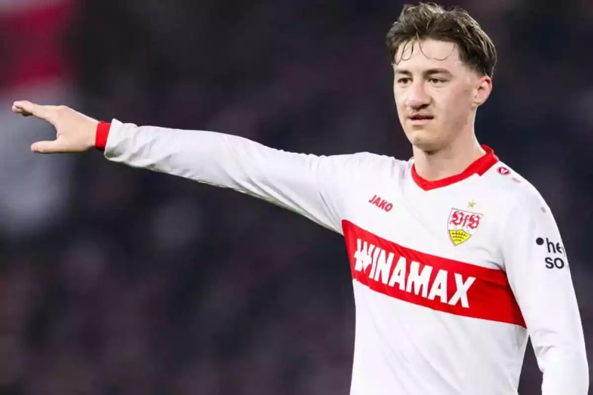 Futbolista con uniforme blanco y rojo del Stuttgart señalando con el brazo extendido durante un partido Futbolista con uniforme blanco y rojo del Stuttgart señalando con el brazo extendido durante un partido