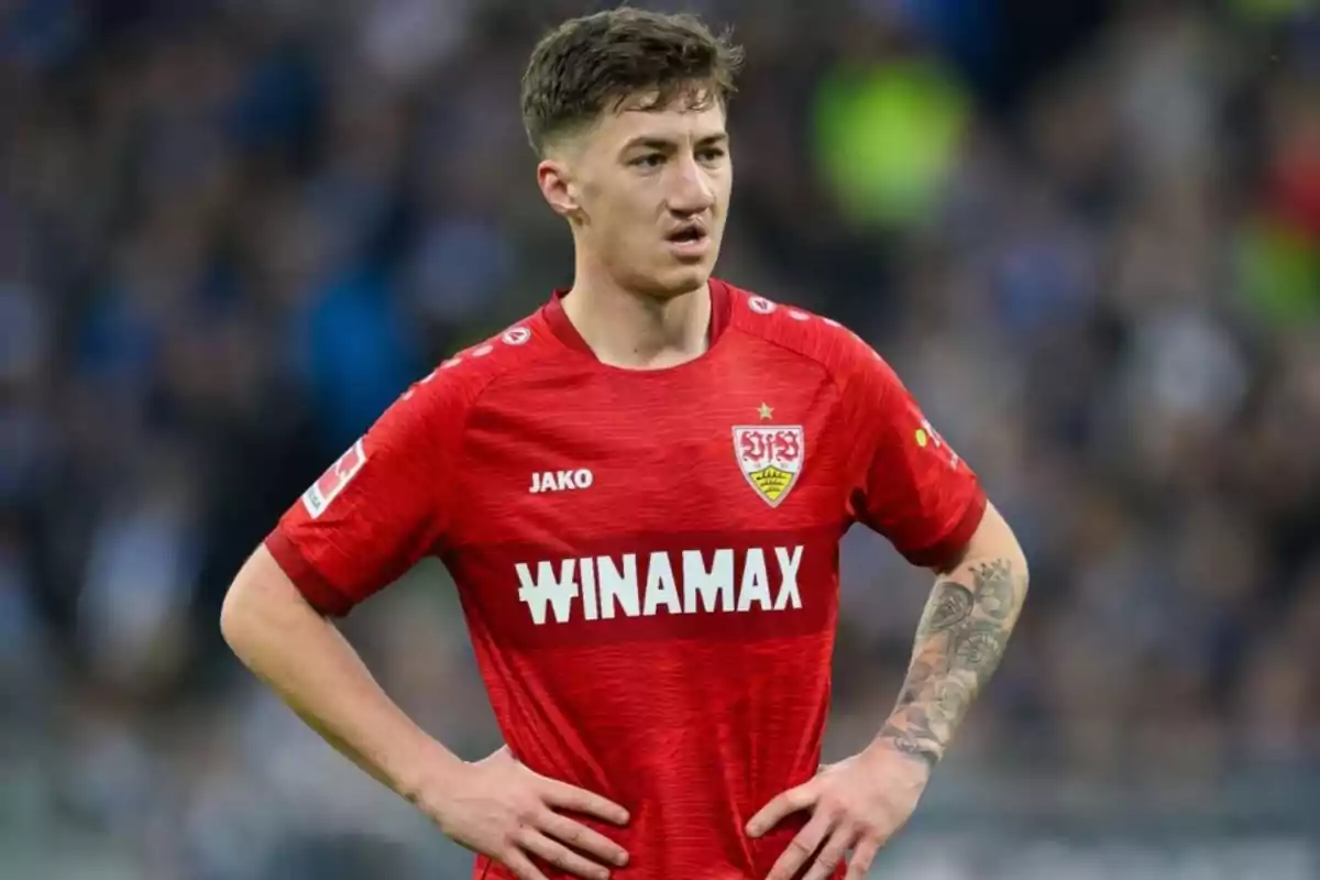 Soccer player in a red Stuttgart uniform on the field with hands on hips Soccer player in a red Stuttgart uniform on the field with hands on hips