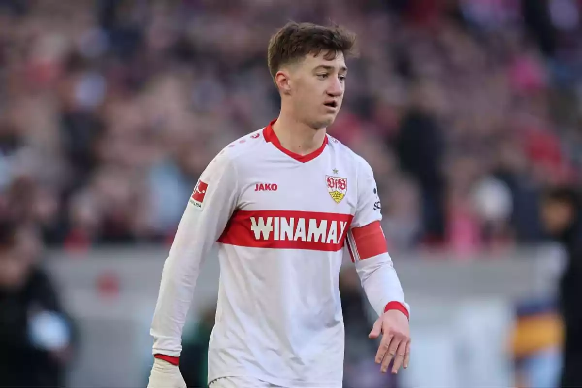 Un jugador de fútbol con uniforme blanco y rojo en el campo durante un partido. Un jugador de fútbol con uniforme blanco y rojo en el campo durante un partido.