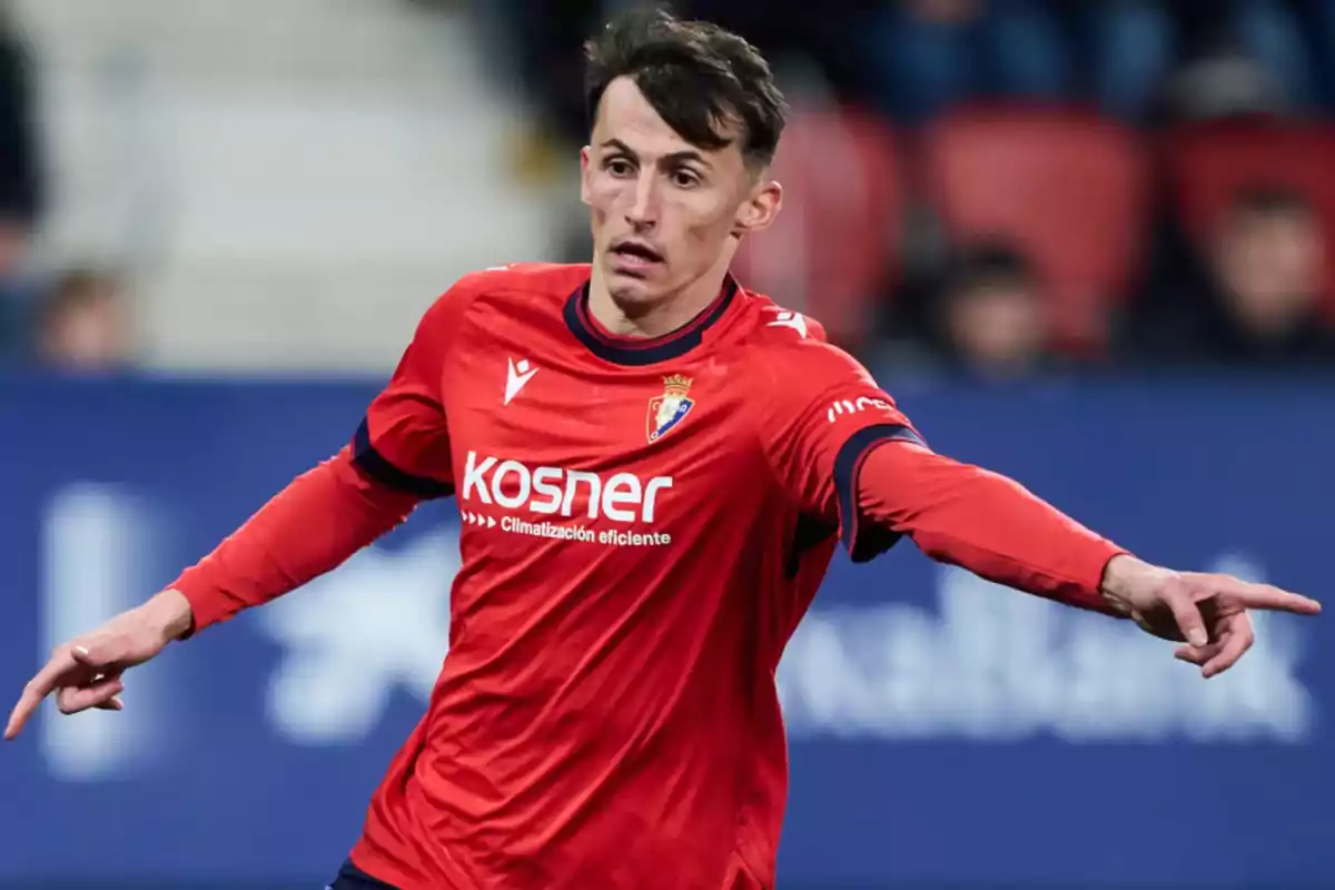 Un jugador de fútbol con uniforme rojo en acción durante un partido. Un jugador de fútbol con uniforme rojo en acción durante un partido.