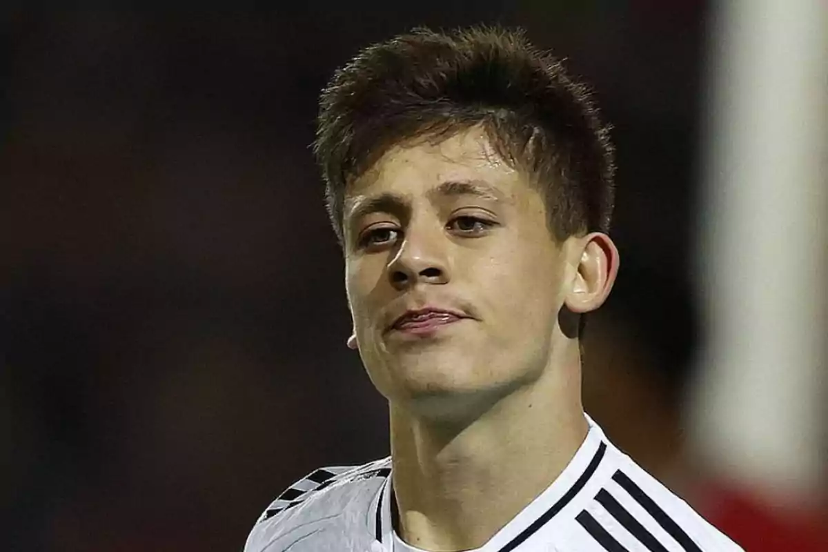 A young man in a black and white sports jersey looks forward with a serious expression. A young man in a black and white sports jersey looks forward with a serious expression.