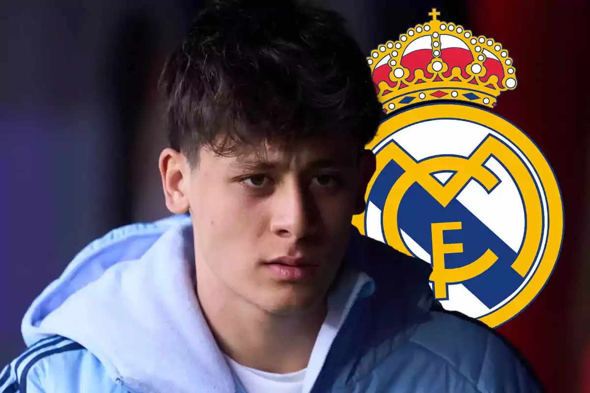 A young man in a light blue sweatjersey in front of the Real Madrid crest.