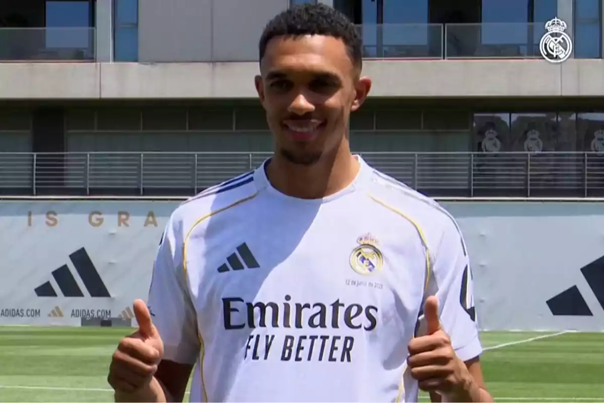 Soccer player in a white Real Madrid uniform posing on the field and giving two thumbs up Soccer player in a white Real Madrid uniform posing on the field and giving two thumbs up