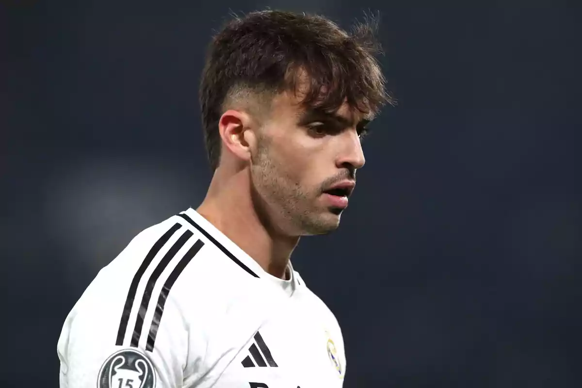 Jugador de fútbol con camiseta blanca y detalles negros durante un partido Jugador de fútbol con camiseta blanca y detalles negros durante un partido
