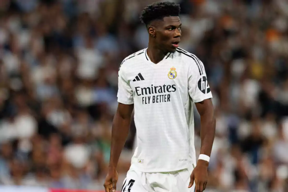 A Real Madrid soccer player on the field during a match, wearing the team's white uniform. A Real Madrid soccer player on the field during a match, wearing the team's white uniform.