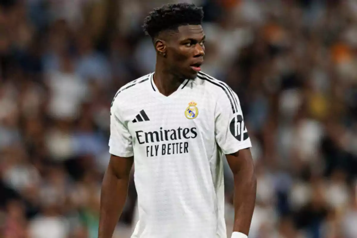 A soccer player in the white uniform of Real Madrid on the field.