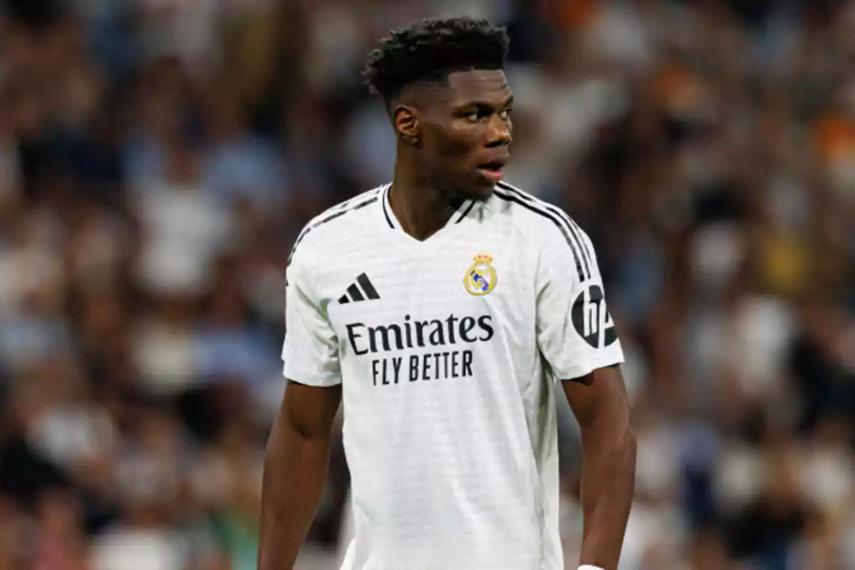 A soccer player in the white uniform of Real Madrid on the playing field.