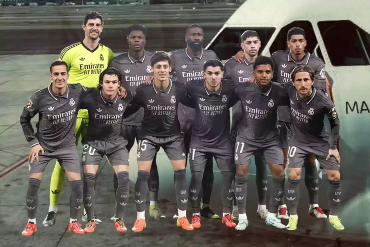 Un grupo de jugadores de fútbol del Real Madrid posando frente a un avión en un aeropuerto.