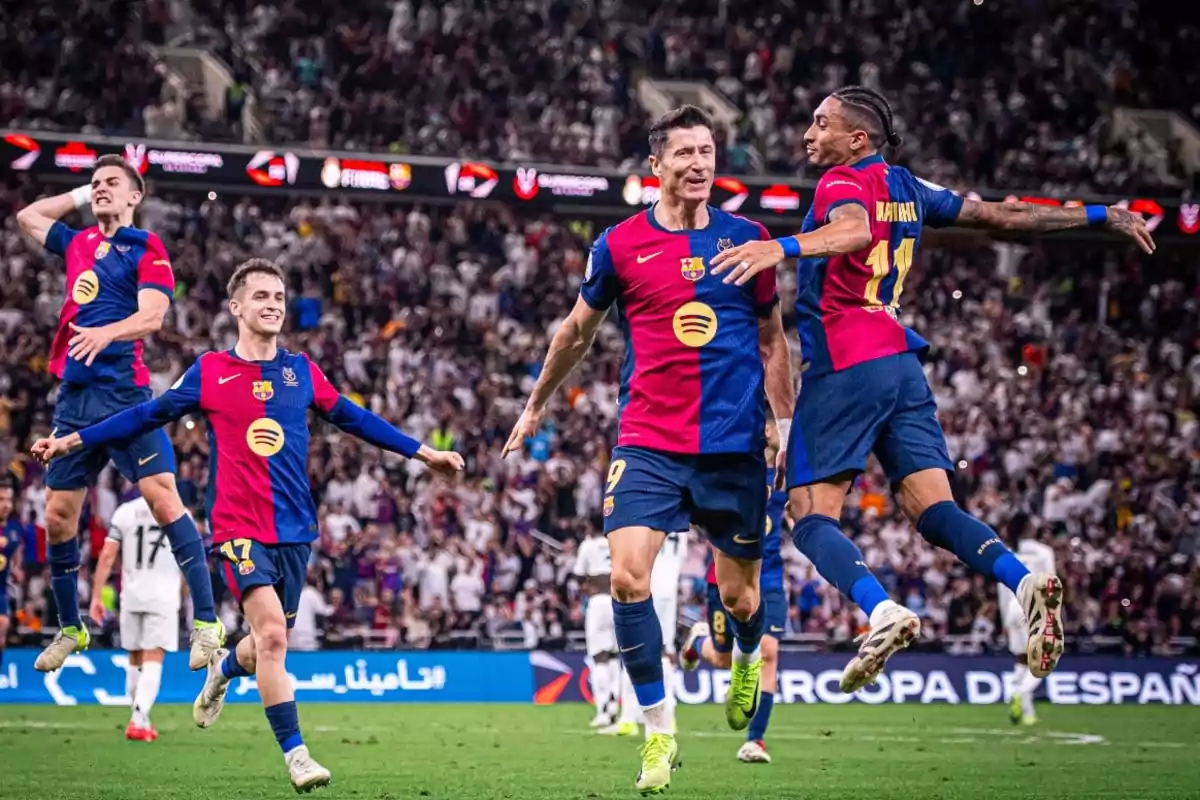Barcelona football players celebrate a goal on the field with the crowd in the background. Barcelona football players celebrate a goal on the field with the crowd in the background.