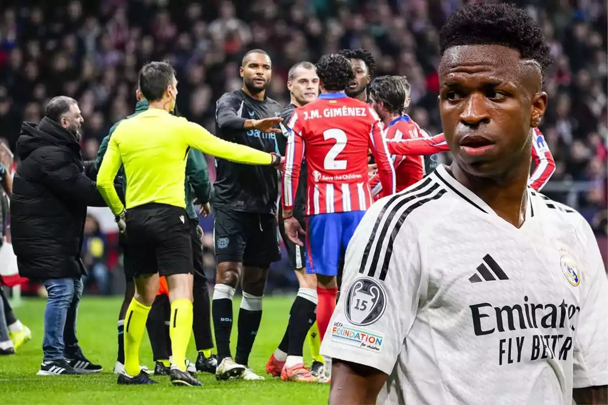 A soccer player in a white uniform is in the foreground, while in the background several players and a referee are seen discussing on the field.