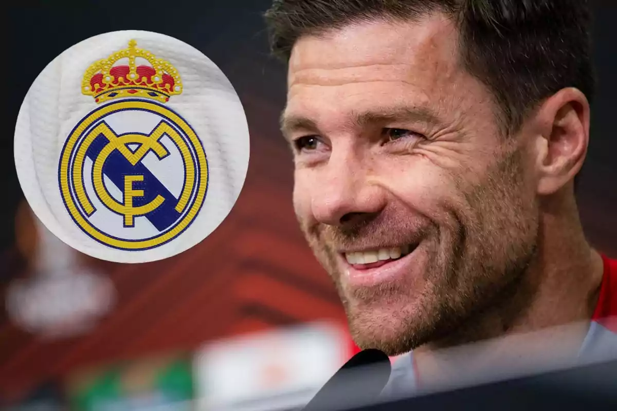 A smiling man next to the Real Madrid crest.