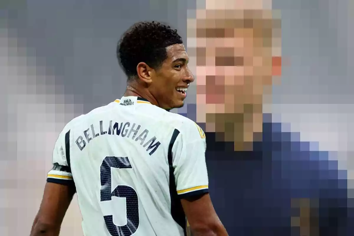 Jugador de fútbol con camiseta blanca y el número 5 en la espalda, sonriendo mientras mira hacia un fondo pixelado.