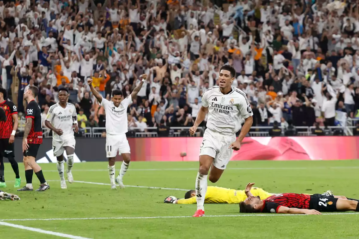 Soccer players celebrate a goal in a stadium full of excited fans. Soccer players celebrate a goal in a stadium full of excited fans.